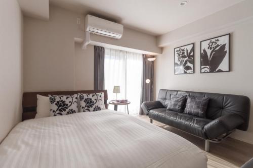a bedroom with a bed and a couch at LANG HOTEL Kameido - Vacation STAY 76905v in Tokyo