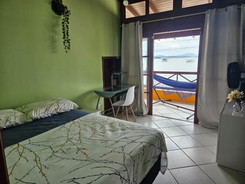 a bedroom with a bed and a view of the ocean at Aspidiske in Governador Celso Ramos