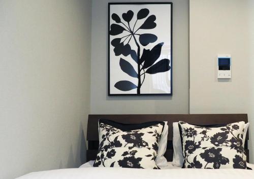 - une chambre avec une photo au-dessus d'un lit et des oreillers dans l'établissement LANG HOTEL Kameido - Vacation STAY 71097v, à Tokyo