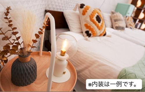 a room with a bed with a candle on a table at Riverside Glamping Nuts - Vacation STAY 78016v in Yamakami