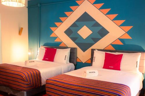 two beds sitting next to each other in a room at Socialtel Atitlan in Panajachel