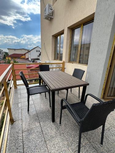a wooden table and chairs on a balcony at Ego Apartments in Drobeta-Turnu Severin