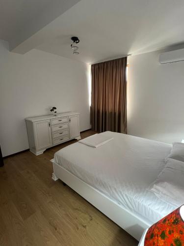 a bedroom with a large white bed and a window at Ego Apartments in Drobeta-Turnu Severin