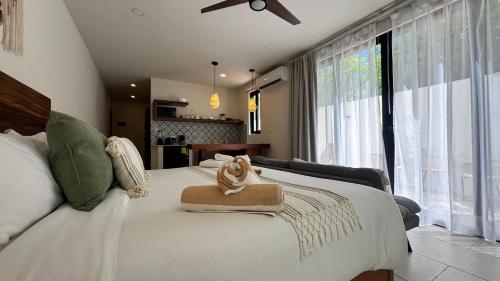 a bedroom with a white bed with a stuffed animal on it at Santal Tulum Condo Hotel By Marea in Tulum