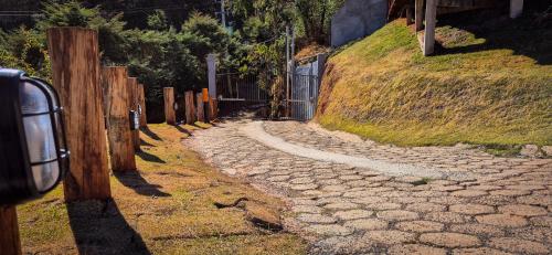 a stone road next to a fence on a hill at ANC MONTANHA - 8min do capivari in Campos do Jordão