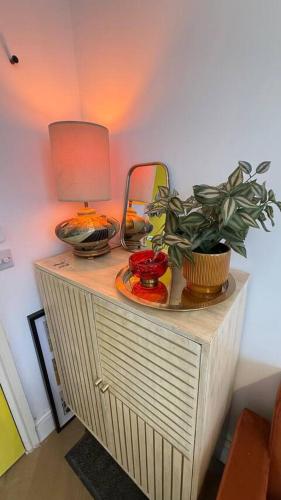 a table with a lamp and a plant on it at Cosy 1 Bed Boutique City Stay in Wolverhampton