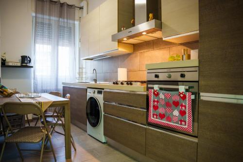 una cucina con fornelli e lavatrice di La Casa di Gabri Humanitas ForumAssago Milano centro a Rozzano