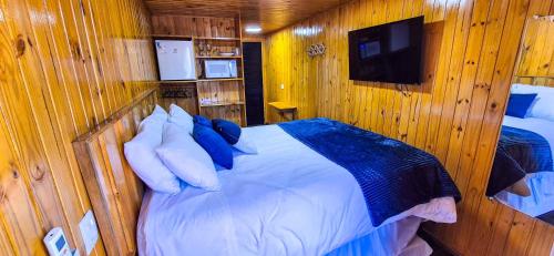 a bedroom with a bed in a wooden room at ANC MONTANHA - 8min do capivari in Campos do Jordão