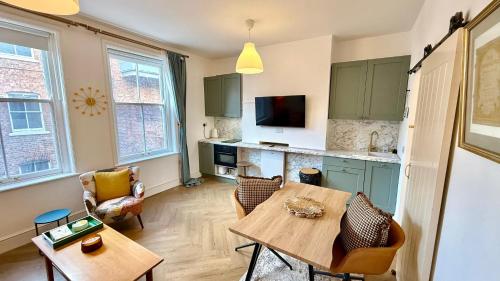 a living room with a table and a kitchen at Cosy 1 Bed Boutique City Stay in Wolverhampton