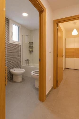 a bathroom with a toilet and a tub and a sink at Area Suites in Jove