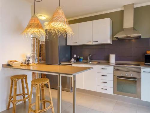 a kitchen with white cabinets and bar stools at Live Victoria Dreamhouse in La Victoria de Acentejo