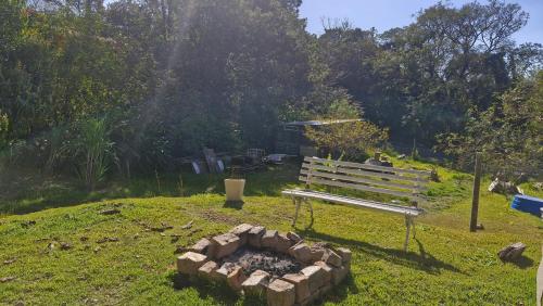 a park bench sitting next to a fire pit at Pe na Pedra quarto 3 in Atibaia