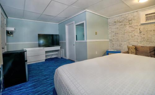 a hotel room with a bed and a television at The Janmere Motel in Hampton
