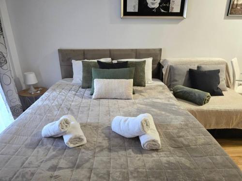 a bedroom with two beds with slippers on the bed at Slavia center apartment in Belgrade