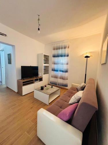 a living room with a couch and a television at La casa della rondine in Rapallo