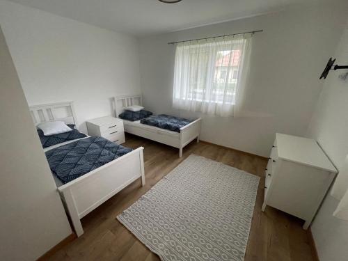 a bedroom with two beds and a window at Csenkő Vendégház 