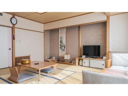 a living room with a table and a tv at Ouka no sato La-Foret Shobara - Vacation STAY 67406v in Shōbara