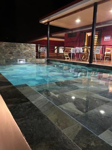 a swimming pool at night with chairs and tables at Vai'Ute'Ute Lodge, Raiatea in Tevaitoa