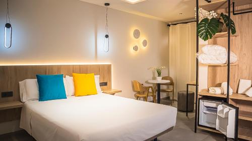 ein Schlafzimmer mit einem großen weißen Bett mit bunten Kissen in der Unterkunft Villas Del Acebuche in Córdoba