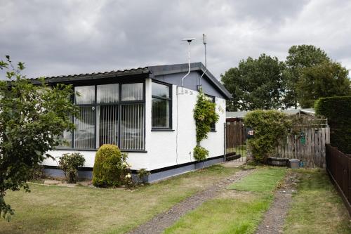 a white house with a fence and a yard at Pet Haven Humberston Fitties Cleethropes Lincolnshire in Humberston