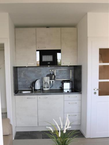 a kitchen with white cabinets and a sink at Nordsee 04 in Cuxhaven