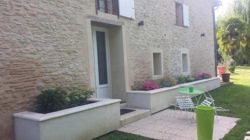 a patio with a table and chairs in front of a building at Le Clos d'Any in Fontet