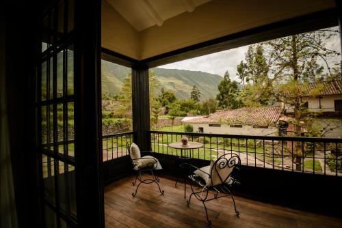 a room with a large window with a table and chairs at Sonesta Posadas del Inca - Valle Sagrado Yucay Urubamba in Urubamba