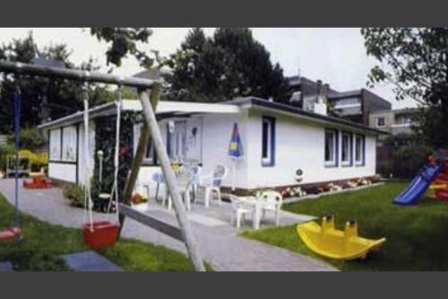 a house with a playground with a slide at Badehausallee 20 Bungalow in Cuxhaven