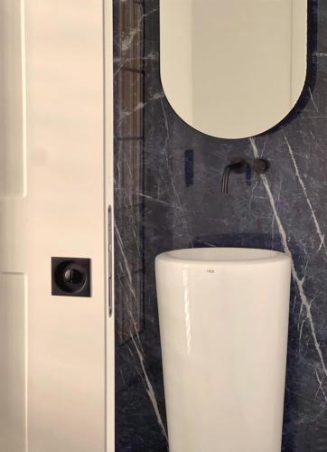 a white toilet in a bathroom with a mirror at Cefalù Luxury Suite in Cefalù