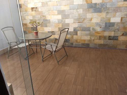 a table and chairs in a room with a wall at Hotel e Motel Rarus in Igaratinga