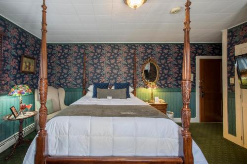 a bedroom with a large bed with blue wallpaper at Stroudsmoor Country Inn in Stroudsburg