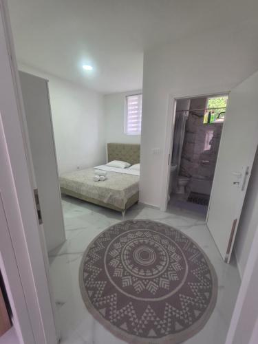 a bedroom with a bed and a rug on the floor at App 3 Ville Adan in Donji Zemunik