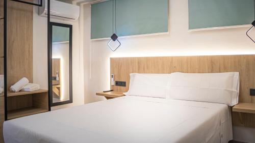 a bedroom with a large white bed and a mirror at Villas Del Acebuche in Córdoba