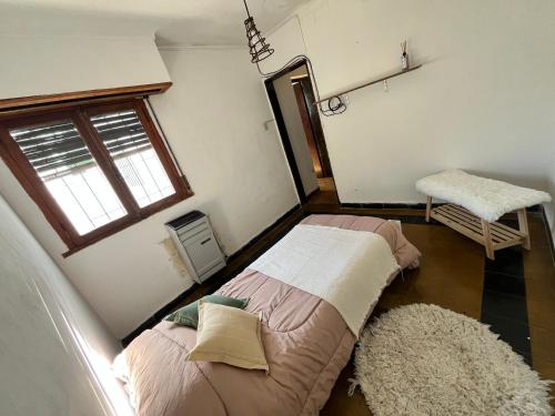two beds in a room with a window and a rug at Casa en alquiler in Tandil