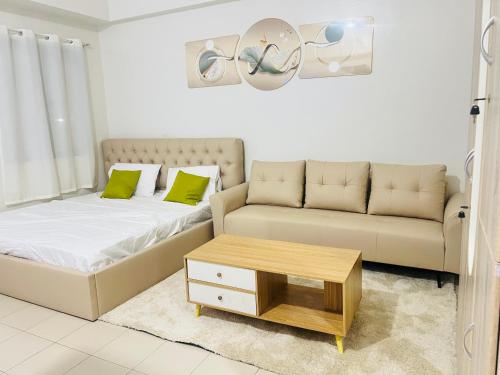 a living room with a bed and a couch at Hill Residence by Sarah Rentals in Manila
