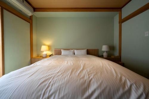 a large white bed in a room with two lamps at Villa Mille - Vacation STAY 19589 in Ito