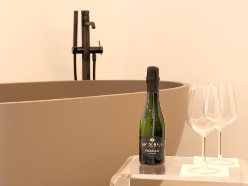 a bottle of wine sitting next to two wine glasses at Cefalù Luxury Suite in Cefalù