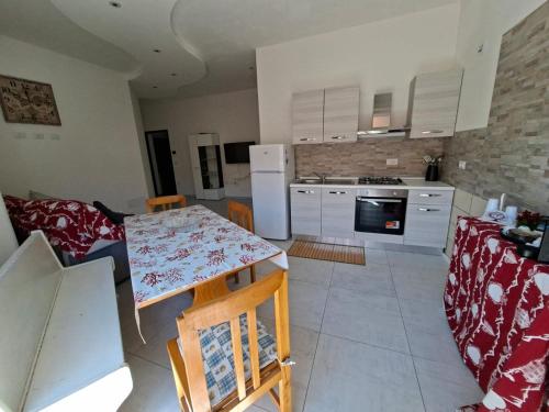 een keuken met een tafel en een keuken met witte apparatuur bij APPARTAMENTO Dal Duca Enrico in Castelsardo