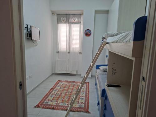 een kamer met een ladder en een tapijt op de vloer bij APPARTAMENTO Dal Duca Enrico in Castelsardo