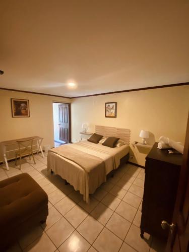 a bedroom with a large bed and a table at Casa Escalante Hostel in San José