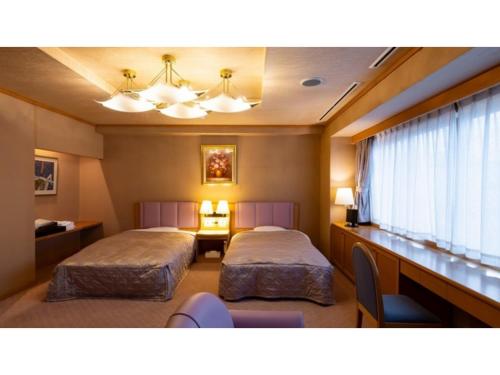 una camera da letto con due letti, una scrivania e una finestra di Hotel Symphony - Vacation STAY 85391v a Sagae