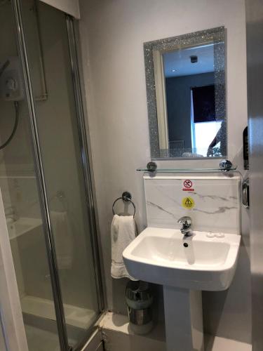 a bathroom with a sink and a shower and a mirror at Watton Vibe Hotel in Watton