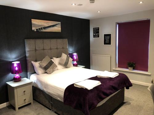 a bedroom with a large bed with two lamps on it at Watton Vibe Hotel in Watton