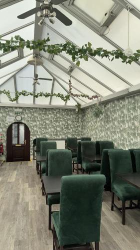 a waiting room with green chairs and a ceiling at Watton Vibe Hotel in Watton