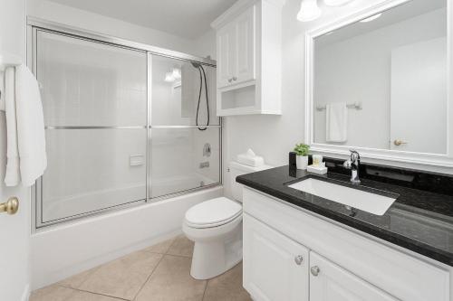 a white bathroom with a toilet and a glass shower at 3Q/2B Perto da DISNEY, Piscina Privativa in Kissimmee