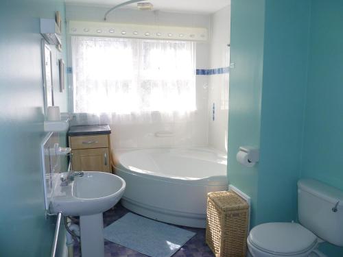 a bathroom with a tub and a sink and a toilet at 9 Rock Towers in Looe