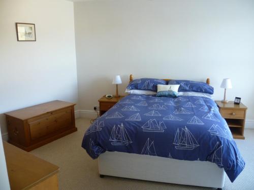 a bedroom with a bed with a blue comforter at 9 Rock Towers in Looe