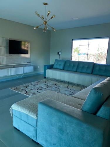 a blue living room with a couch and a television at Pousada Recanto do Oásis in Triunfo