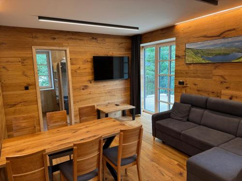 a living room with a couch and a table at PEC 140 - apartmány Máj in Pec pod Sněžkou