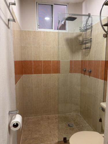 a bathroom with a shower with a toilet and a window at MAI Cozy Apartment 2BR AC and Parking Quiet Stay in Puerto Vallarta